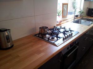 Hoogglans keuken met houten blad. Intia Meubelmaker