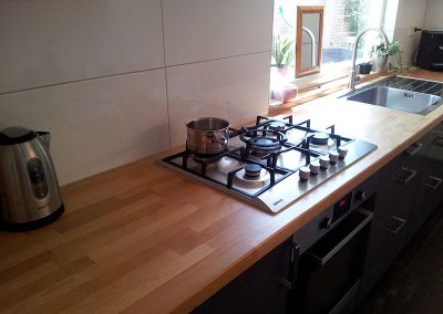 Hoogglans keuken met houten blad. Intia Meubelmaker